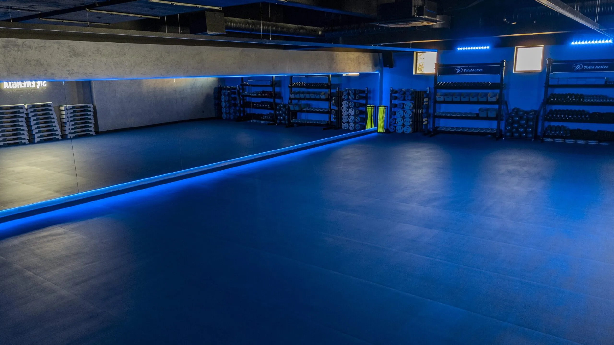 Sala zajęć grupowych z lustrem i niebieskim oświetleniem